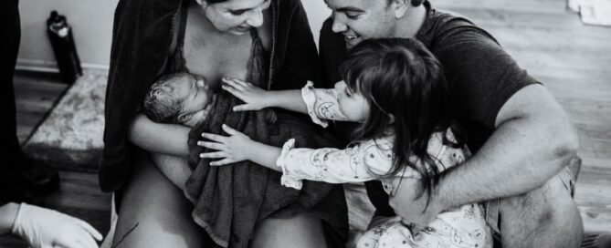 family welcoming baby after birth in birth center