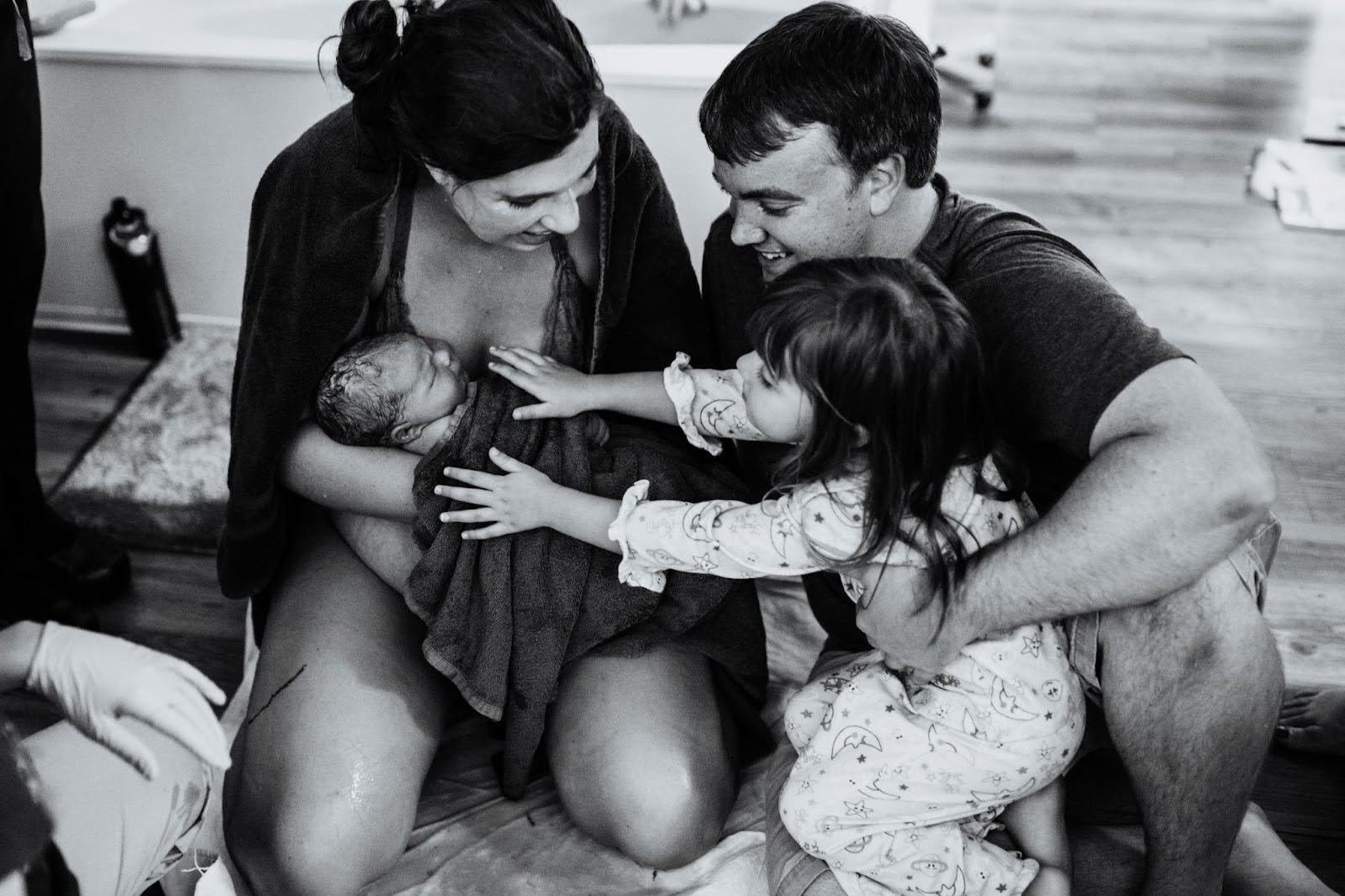 family welcoming baby after birth in birth center